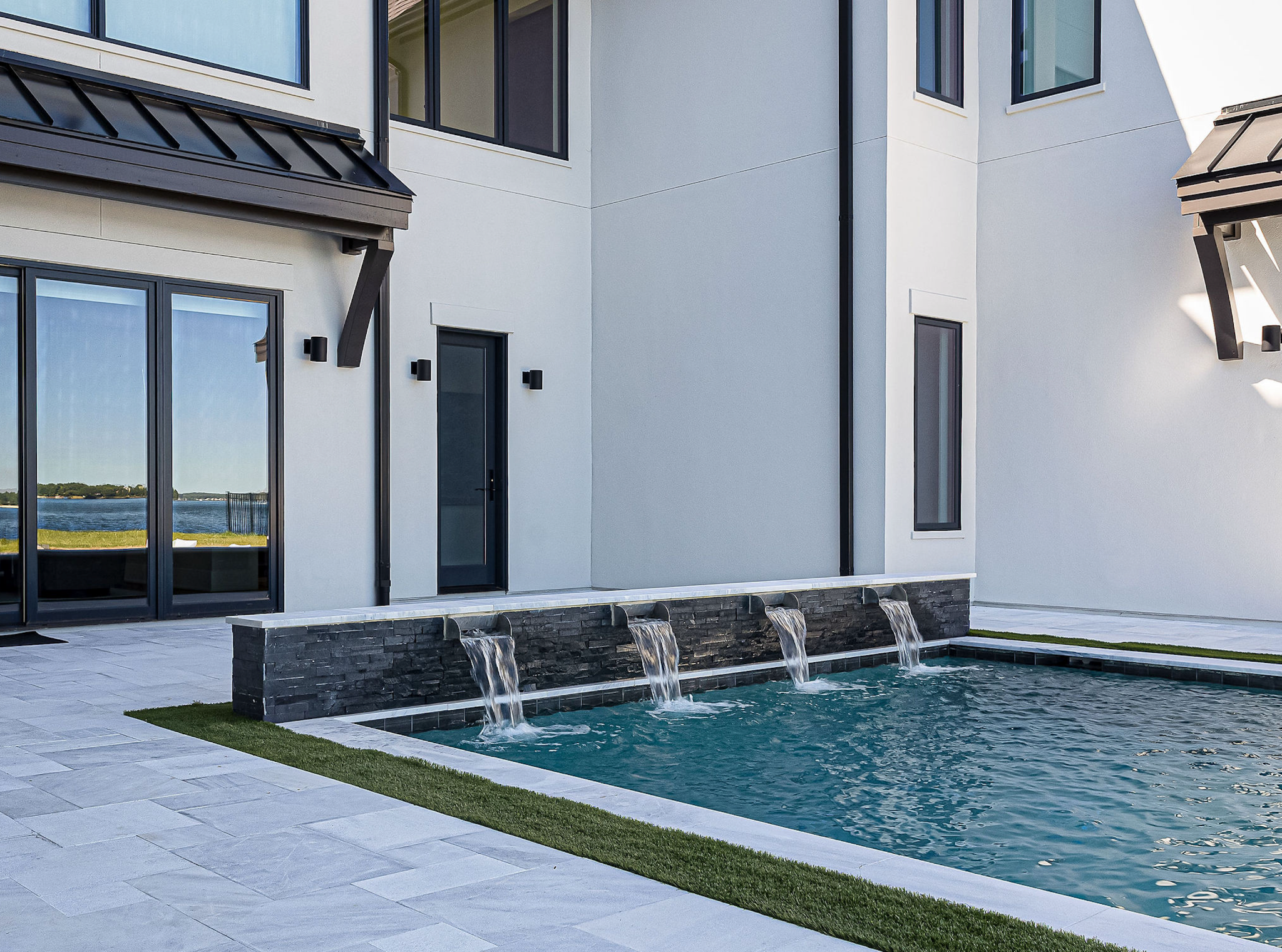 Lakefront home courtyard with a reflecting water feature